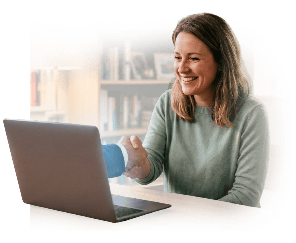 Woman smiling during online meeting with handshake on laptop.