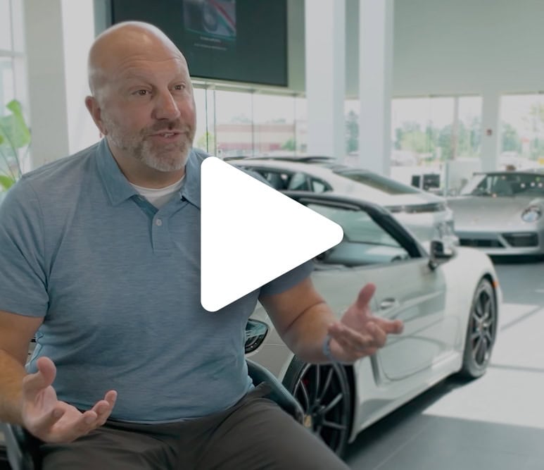 Man discussing customer engagement solutions at a car dealership.
